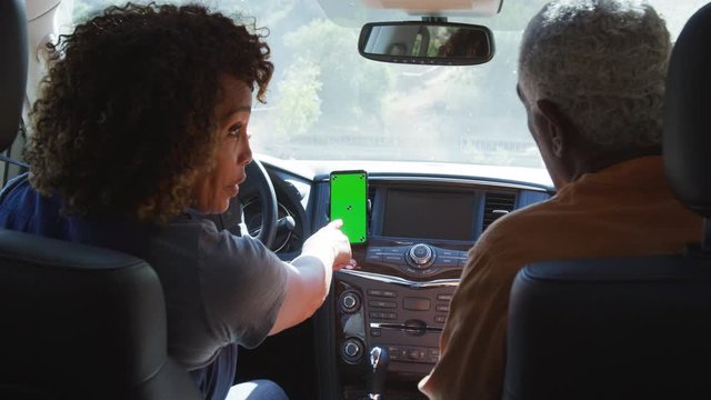 Rear View Of Senior African American Couple On Drive Through Countryside Using Sat Nav On Mobile Phone - Shot In Slow Motion