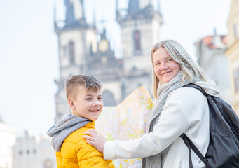 Happy family holds map on the old town square in Prague. Empty space for text