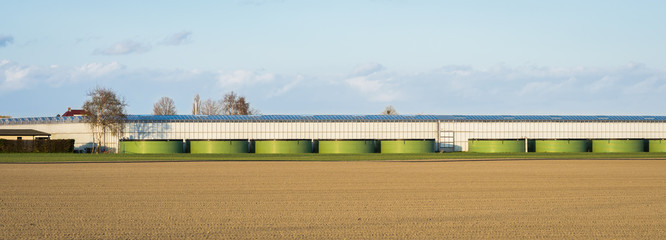 Fototapeta premium Panoramic view of greenhouses with water basins for irrigation