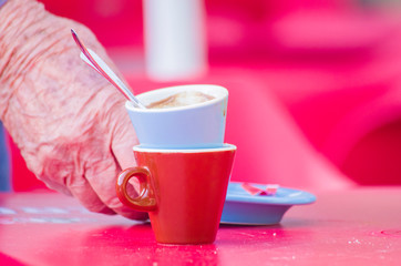 the old barista takes away the coffee cups to wash them