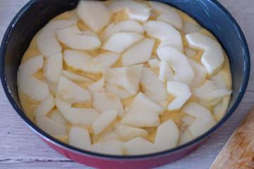 baking dish with dough and slices of pear.