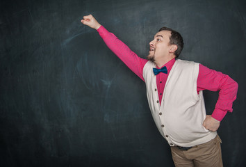 Portrait of funny nerd man in superhero pose on blackboard