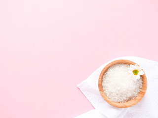 Spa flatlay composition. Sea salt, bath towel, flower on pink background. Copyspace, top view. Home care concept