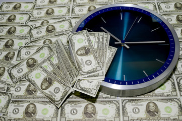 The concept of time is money, a wall clock against a pile of thousand-dollar bills