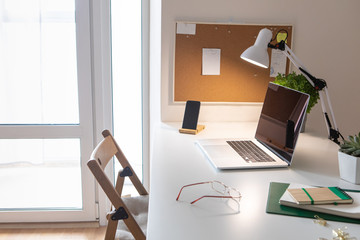 Laptop on office desk interior. Stylish workplace mockup.