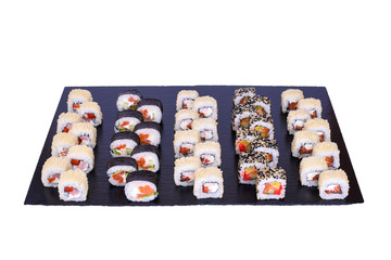 sushi set Hokaido rolls with fresh ingredients on black stone isolated on white background. Sushi menu. Japanese food.