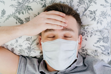 the masked man lies at home in bed close eyes 