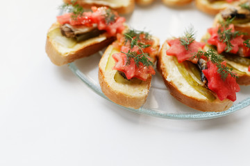 Snack sandwich with sprats cucumber and tomatoes and dill. Delicious sandwiches on a plate.