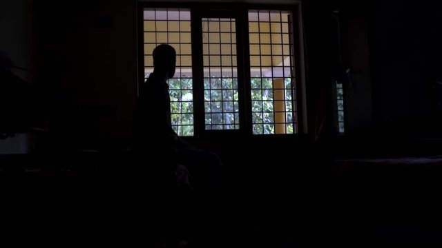 A man's silhouette in front of the window Black and white loneliness alone