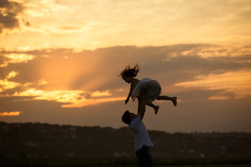 silhouette of dad and daughter. family in village.