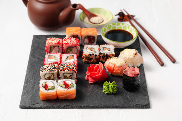 Japanese cuisine. Assorted sushi maki gunkan roll on white table