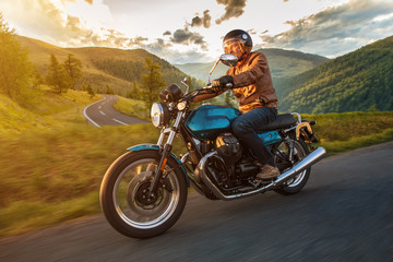 Obraz na płótnie Canvas Motorcycle driver riding in Alpine highway, Nockalmstrasse, Austria, central Europe.