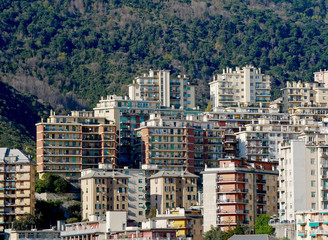 Edilizia residenziale sulle colline della città di Genova con parco urbano sullo sfondo. 