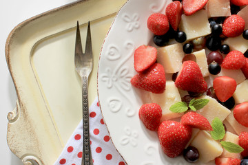 Parmesan cheese with strawberry on a serving plate.