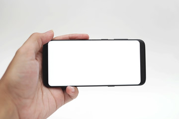 Hand hold smartphone in landscape mode blank mock-up isolated white background