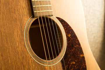 Obraz premium Brown wooden guitar with warm light close up