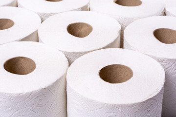 Piled up toilet paper rolls close up from the front at an angle