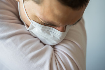 Medical mask close up on white male dry coughing with white background, Corona protection.
