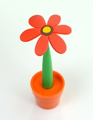 Artificial flower. Beautiful soft plastic flower in a flower pot isolated on a white background. 