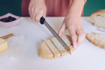 Woman cutting bread at  kitchen
