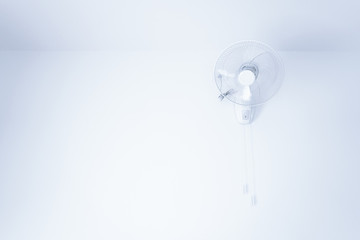 Wall mount electric white fan,electric fan hanging on white mortar wall