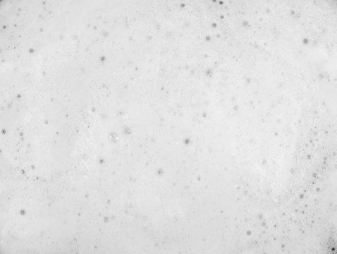 White foam on black background. Foam bubble from soap or shampoo washing on top view. Foam background. White foam.