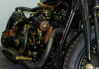 Fototapeta na wymiar WROCLAW, POLAND - August 11, 2019: USA cars show: Fragment of vintage stylish black and copper coloured engine with exhaust system pipes and side lights of restored motorcycle closeup