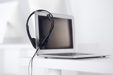 Call center and communication support, customer service help desk. VOIP headset on laptop computer