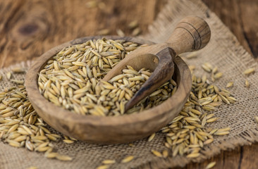 Vintage wooden table with Oat (selective focus; close-up shot)