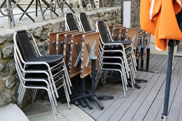 Tables et chaises de bistrot entassées sur une terrasse de restaurant. Fermeture adminsitrative et gouvernementale. Coronavirus. Covid-19. Saint-Gervais-les-Bains. Haute-Savoie. France.