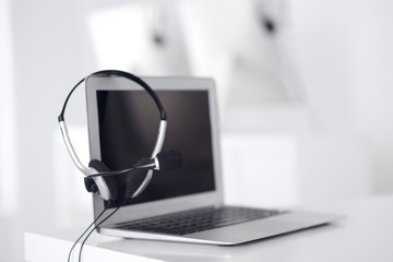 Call center and communication support, customer service help desk. VOIP headset on laptop computer