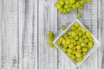Some fresh White Grapes on wooden background (selective focus; close-up shot)
