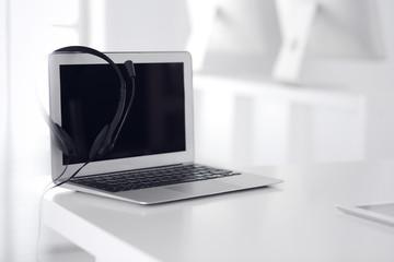 Call center and communication support, customer service help desk. VOIP headset on laptop computer