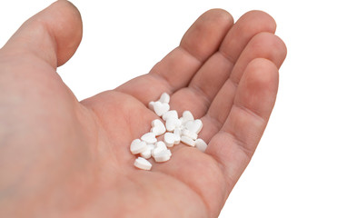 in the hand, on the palm of the person cute white pills with hearts