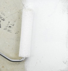 Obraz premium Painting a rough wall with roller. Paint roller leaving stroke of white color over a rustic background. usable for text and messages.