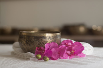 singing bowls and flowers on towel