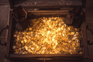 Chest full of gold and silver coins in castle, view from top, flat lay