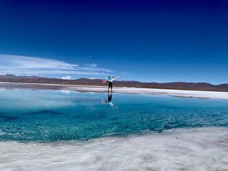 Couple devant les salines (d&eacute;sert de sel) d'Am&eacute;rique du Sud