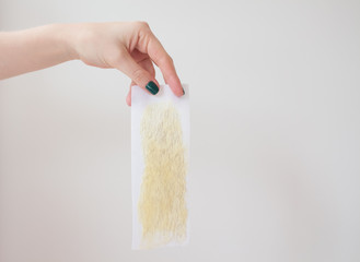  used wax strips on a white background shows a young woman with a beautiful manicure
