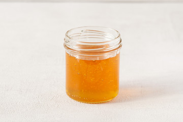 Honey jar or pot isolated on grey background. 