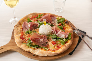 Pizza with mozzarella and raw ham