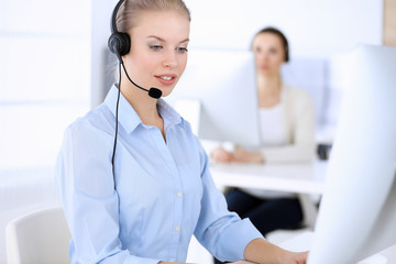 Call center. Group of operators working as customer service occupation.Beautiful woman receptionist in headset. Business people concept