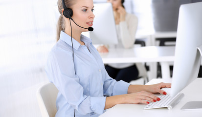 Call center. Group of operators working as customer service occupation.Beautiful woman receptionist in headset. Business people concept