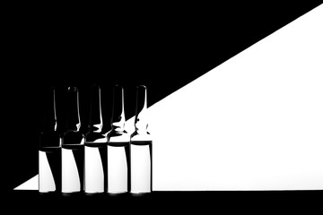 Medicine ampoules on black and white geometric background. High contrast image of ampoules.