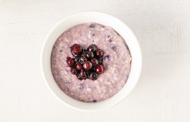 Oatmeal bowl with blueberries for healthy breakfast isolated on grey background. Top view. 