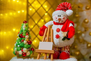 Christmas tree and snowman close-up on a yellow Christmas background