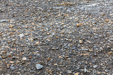 The land is covered with small granite stones. Can be used for background.