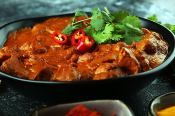 Chicken tikka masala spicy curry meat food in pot with rice and naan bread. indian food on table
