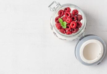 Overnight oatmeal with raspberries, blueberries, and yogurt in a jar isolated on grey background. Healthy vegetarian breakfast. Copy space, top view. 