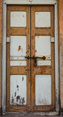 Vintage wooden door with muted shades of brown, bolts and lock detail